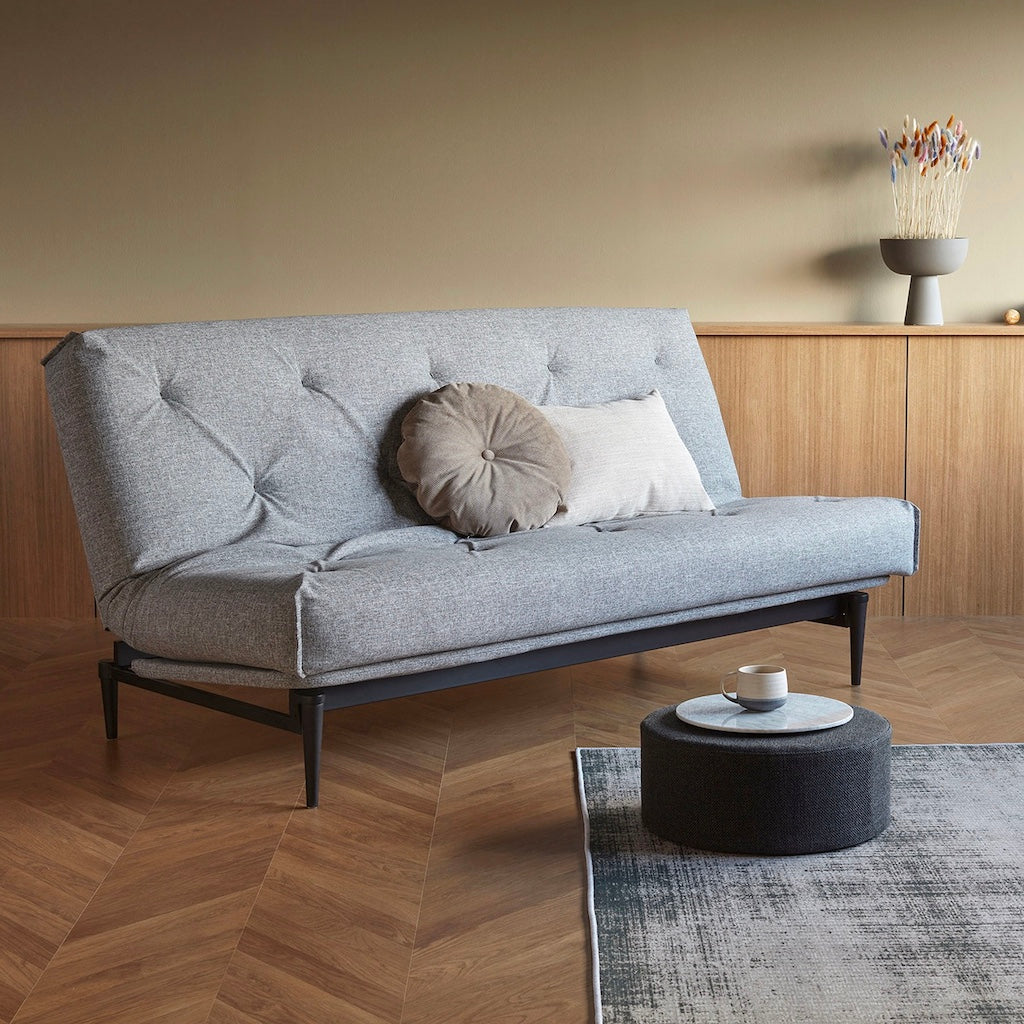 Colpus vuodesohva, jalat mustat, kangas Twist Granite. Kuvassa myös Pauke rahi ja Dapper tyyny.
