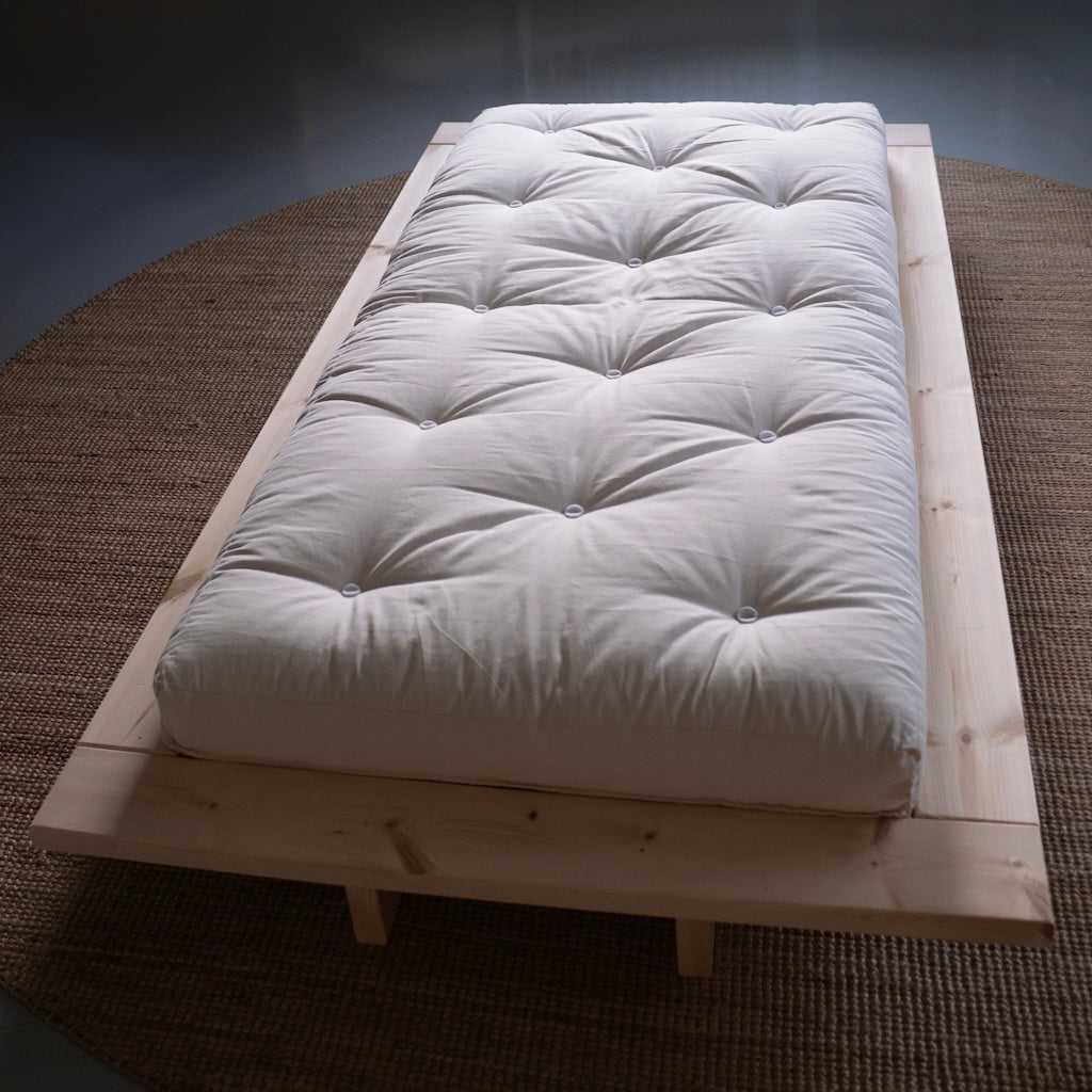 Luonnonvalkoinen futonpatja. Kuvassa myös Japan sänkyrunko.