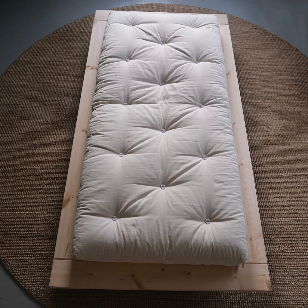 Luonnonvalkoinen futonpatja. Kuvassa myös Japan sänkyrunko.