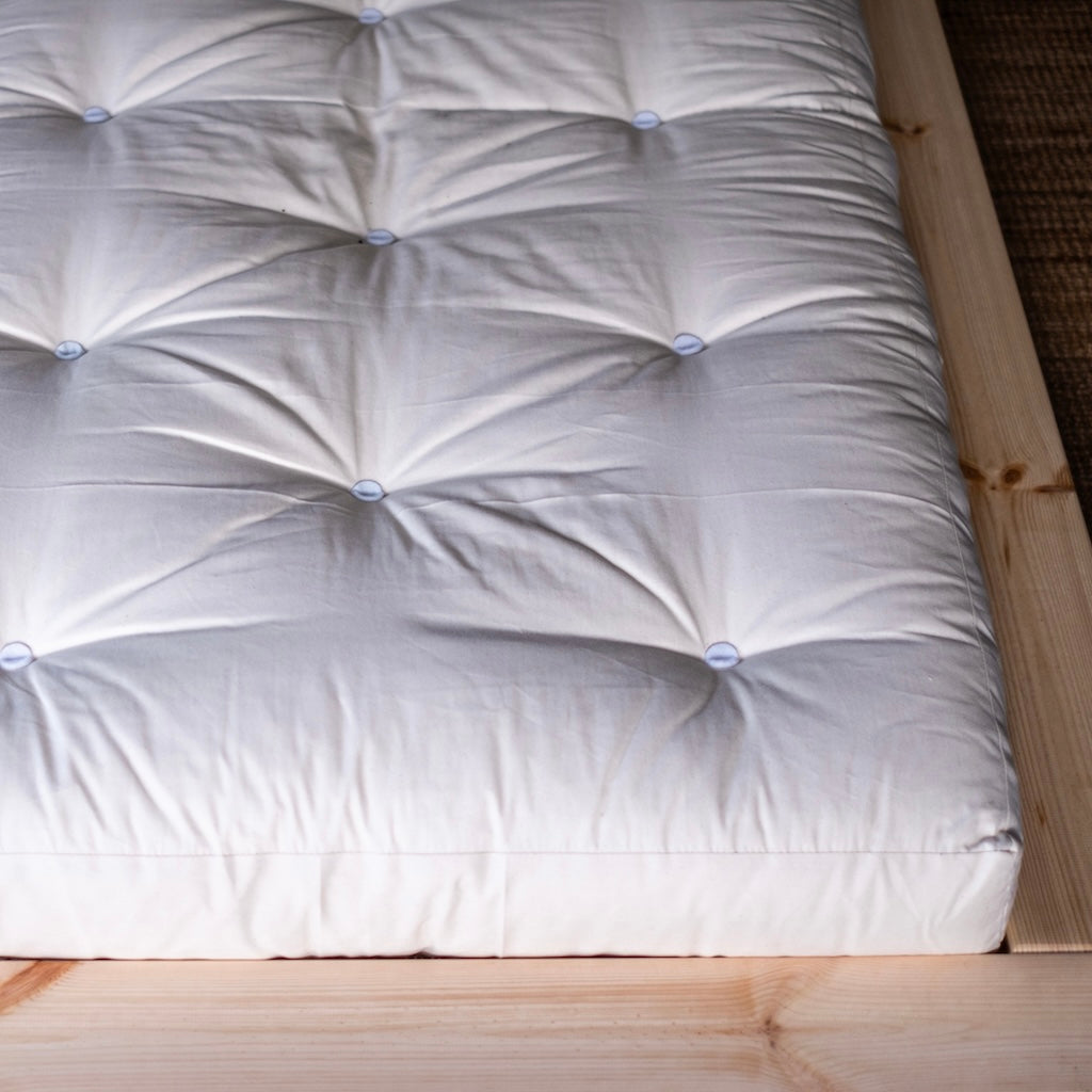 Luonnonvalkoinen futonpatja. Kuvassa myös Japan sänkyrunko.