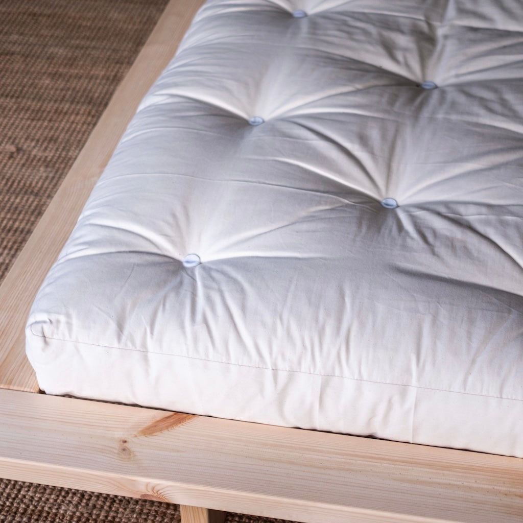 Luonnonvalkoinen futonpatja. Kuvassa myös Japan sänkyrunko.