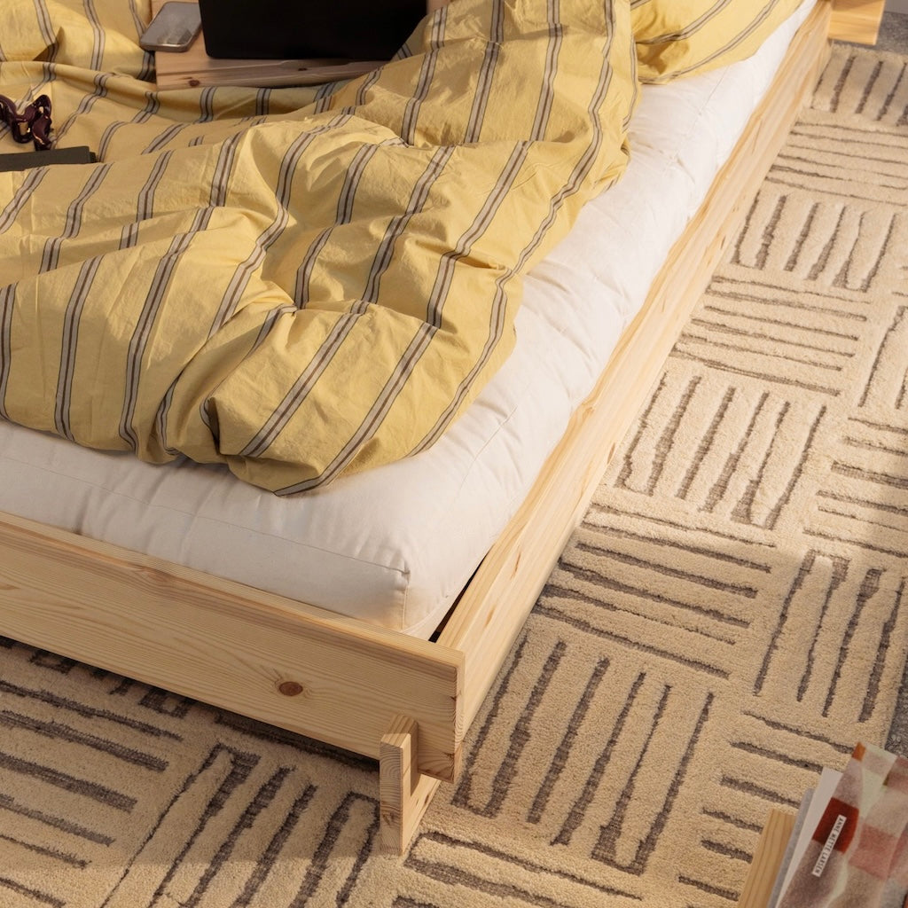 Massiivimäntyinen, käsittelemätön Latch sänkyrunko. Kuvassa myös rekvisiittana futonpatja ja petivaatteita. Lähikuva rungon jalkopäädystä.