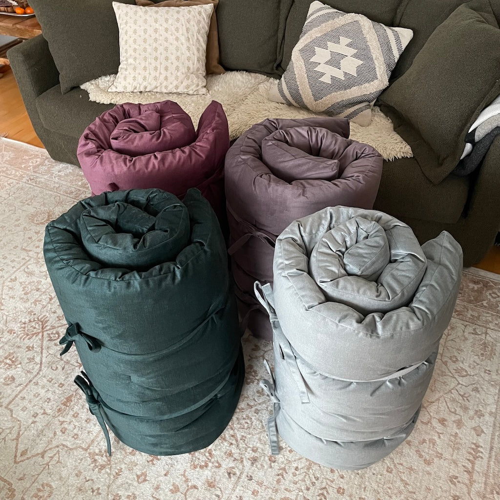 Kuvassa kaksi Roll futonia, kankailla Fancy Akvamariini ja Fancy Tumma Sinivihreä. Kuvassa myös kaksi Joogafutonia, kankailla Fancy Luumu ja Fancy Ruskea.