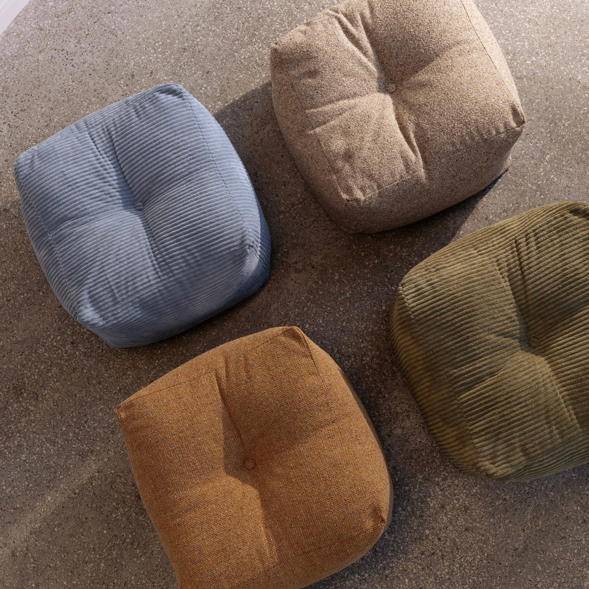 Neljä Buddy Poufia Mega Corduroy samettikankaalla väreissä Hazy Blue ja Khaki Green sekä Textured Weave kankaalla Warm Sand ja Colden Ochre.