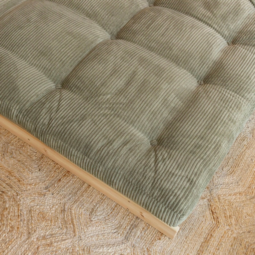 Roots 140 vuodesohva divaaniasennossa. Futonpatjan samettikangas Mega Corduroy, väri Khaki Green. Runko käsittelemätöntä massiivimäntyä. Lähikuva.