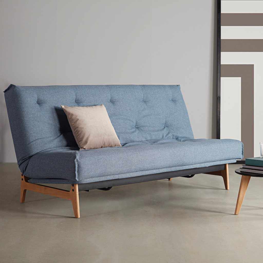 Aslak 120 vuodesohva, kangas Mixed Dance Light Blue. Kuvassa myös erikseen tilattavat rungon istuinosan suojus, Dapper-tyyny ja Nordic-pöytä.