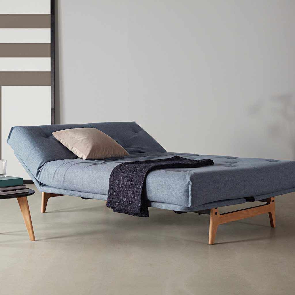 Aslak 120 vuodesohva, kangas Mixed Dance Light Blue. Kuvassa myös erikseen tilattavat rungon istuinosan suojus, Dapper-tyyny ja Nordic-pöytä.